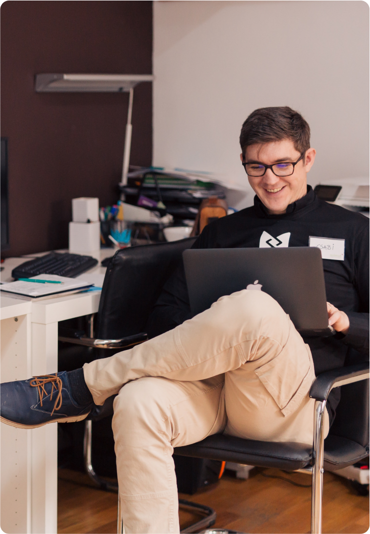 jeune développeur en reconversion professionnelle sur son ordinateur à son bureau